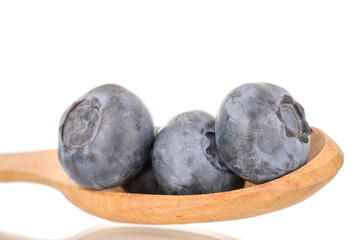A few sweet blueberries with a wooden spoon, macro, isolated on a white background.