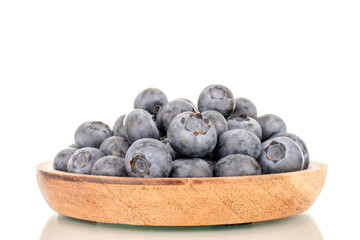 A few sweet blueberries with a wooden saucer, macro, isolated on a white background.