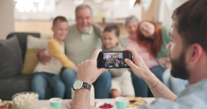 Phone, screen and photographer for family together in home with grandparents, children and mom in a picture or memory. Group, mobile and focus on lens, app or capture portrait of people on smartphone