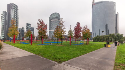 Panorama showing skyscrapers and biblioteca from park with green lawn timelapse in Milan
