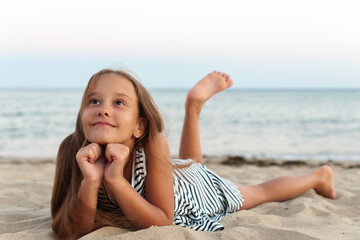 a beauteful  caucasian girl play on the beach  on the sand and relaxes  in casual striped clothing, 