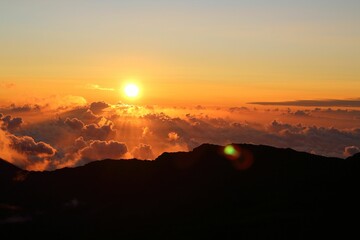 View of majestic mountain landscape with a vibrant sunset sky and white, fluffy clouds
