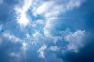 Naklejka na ściany i meble Sunbeam through the cloud on blue sky