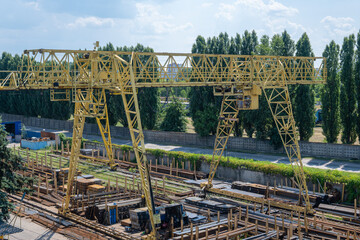 Large yellow rail crane for loading iron pipes