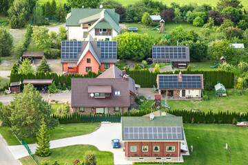 Aerial view of solar panels on the roof of terraced houses in the countryside. Solar power plant....