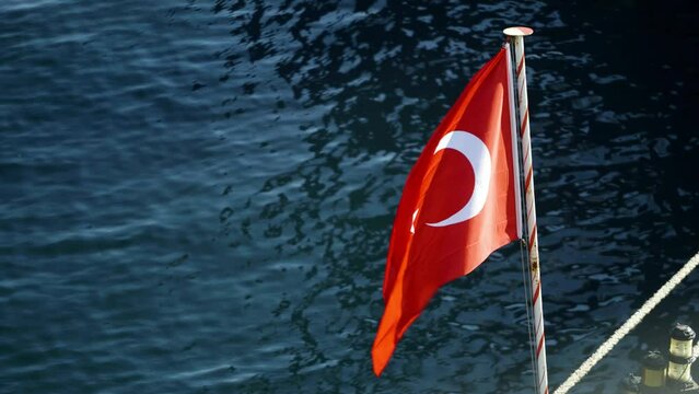 4K close up filming from deck showing Turkish ensign against sea. Waving Turkish flag footage on anchored ship in daylight stock video. 