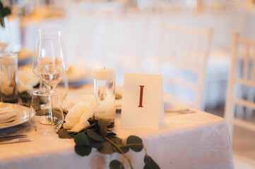 Wedding table setting in white and green tones adorned with a lush display of fresh flowers.