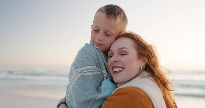 Beach, blanket and mother hug child on a holiday or vacation to be warm and bonding feeling happy. Love, care and mom support kid on cold beach or sea for travel together enjoying quality time