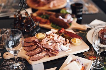 Wooden cutting board with a variety of cured meats.