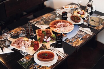 Black table adorned with a variety of food and beverages.