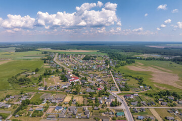 panoramic aerial view of eco village with wooden houses, gravel road, gardens and orchards