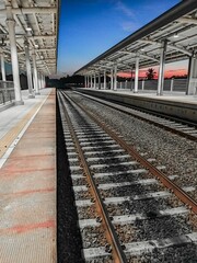 Fototapeta premium a train station with an empty track and a view of the sky