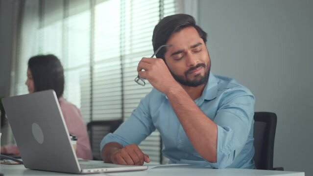 Stress, Serious Indian male frustrated with work sitting in front of a laptop. Mental health, headache or depressed corporate worker with frustrated fail or bad error