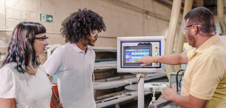 technician from an industry explaining to students from a technical school how the application of a machine works during a class in a factory in Brazil