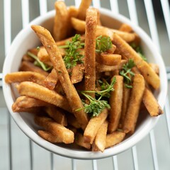 a bowl filled with french fries topped with parsleye