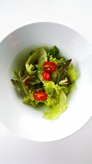 a plate that has a bowl with a salad on it