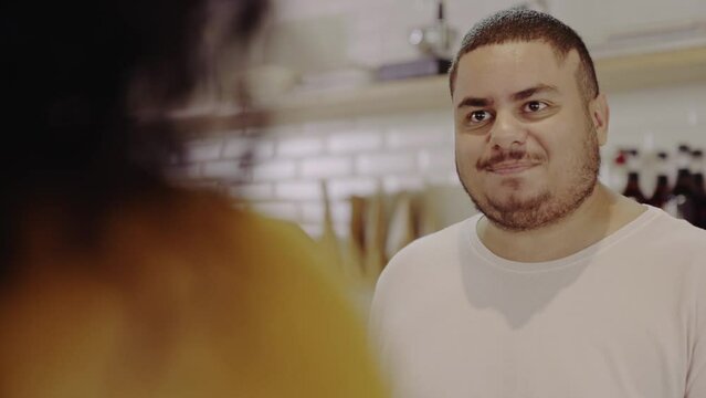 atendente Brasileiro sorrindo conversando com a cliente enquanto ela fecha a sua conta em uma cafeteria no Brasil