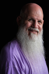 Portrait of happy man with long gray beard wearing purple t-shirt close-up shot