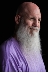 Portrait of man with long gray beard wearing purple t-shirt close-up shot