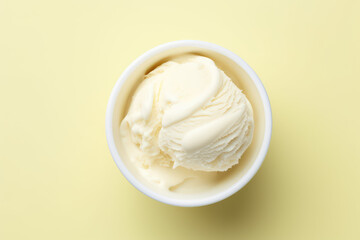 Top view of delicious vanilla milk ice cream in a round white vase isolated on a light pastel yellow background. Copy space for text. Generative AI photo.
