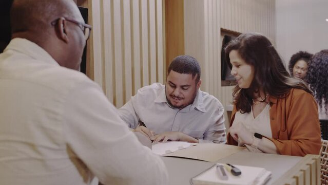 casal Brasileiro assinando um contrato de emprestimo bancario em uma agencia de banco no Brasil