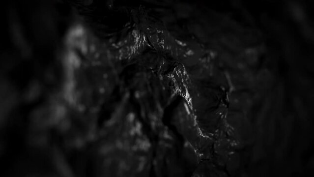Abstract dark liquid waving background close-up. 