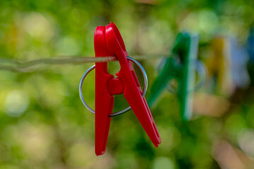 Czerwony spinacz do bielizny wiszący na sznurze do suszenia prania.