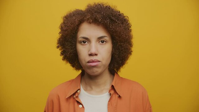 Pensive Woman Looking At Camera Portrait on Yellow