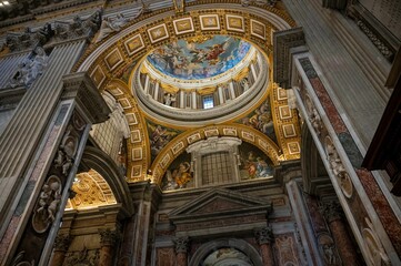 Fototapeta na wymiar Low angle shot of the interior of St peter's Basilica dome with beautiful frescoes