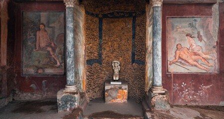 Interior room with aged walls and frescoes in the House of Loreius Tiburtinus, Pompeii, Italy