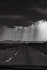 leaking sun rays from strom clouds over the road
