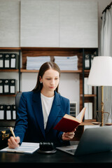  Caucasian Woman lawyer reading legal book with gavel on table in office. justice and law ,attorney...