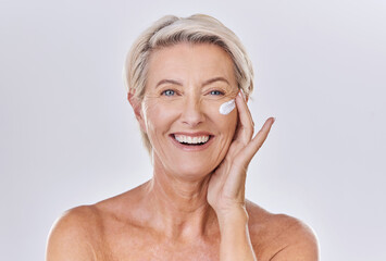 Portrait, cream on face and beauty with old woman, happy with skincare and dermatology on white...