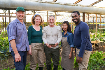 Farmer's team in greenhouse working with tablet computer