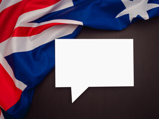 Part of the Australia flag and a blank white speech bubble on a black background.