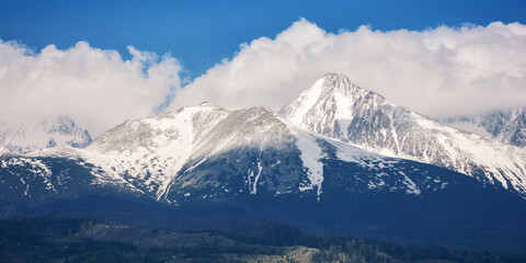 slovakia countryside in spring. snowcapped peaks beneath huge white clouds. nature background in gorgeous light