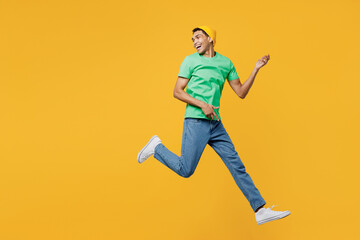 Fototapeta na wymiar Full body profile young man of African American ethnicity he wears casual clothes green t-shirt hat jump high look aside pov play guitar isolated on plain yellow background studio. Lifestyle concept.