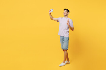 Full body fun young man wear light purple t-shirt casual clothes doing selfie shot on mobile cell...