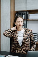 Fototapeta premium Businesswoman is doing a stretchy posture due to sitting in the office for too long, office syndrome concept.