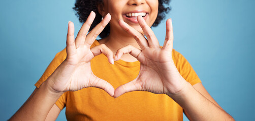 Happy, hand and closeup of a heart shape for romance, care or flirting expression in a studio....
