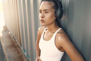 Fototapeta premium Fitness break, breathe or woman running in city listening to music, podcast or radio playlist in sports exercise. Wellness, headphones or tired girl athlete resting after training or workout outdoors