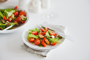 Fresh salad with mussels and tomatoes on white wooden table