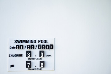 Every day sign of the chlorine and pH of a swimming pool on a white wall