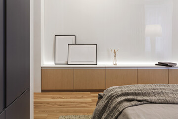 Commode with home decoration against glossy white wall in modern bedroom