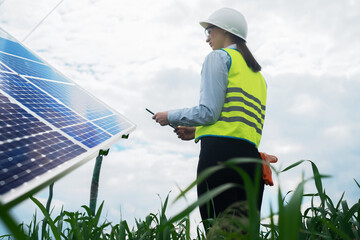 Portrait of a technical engineer with a tablet in his hands, standing in front of an unfinished tall outdoor solar panel of a photovoltaic system, technical engineer girl