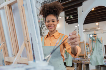 Female African artistartist painting art canvas drawing with inspiration at art studio art therapy creativity concept © Natee Meepian