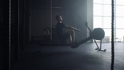 Athletic Man Doing Exercise In Gym, Using Rowing Machine For Developing Power Of Arms