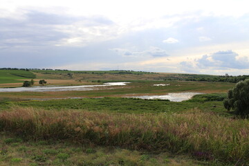 A landscape with a river and grass