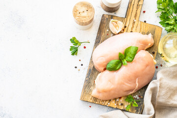 Chicken fillet, raw chicken meat with spices and herbs at white background. Top view with space for text.