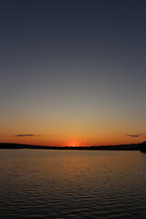 Naklejka premium A sunset over a body of water